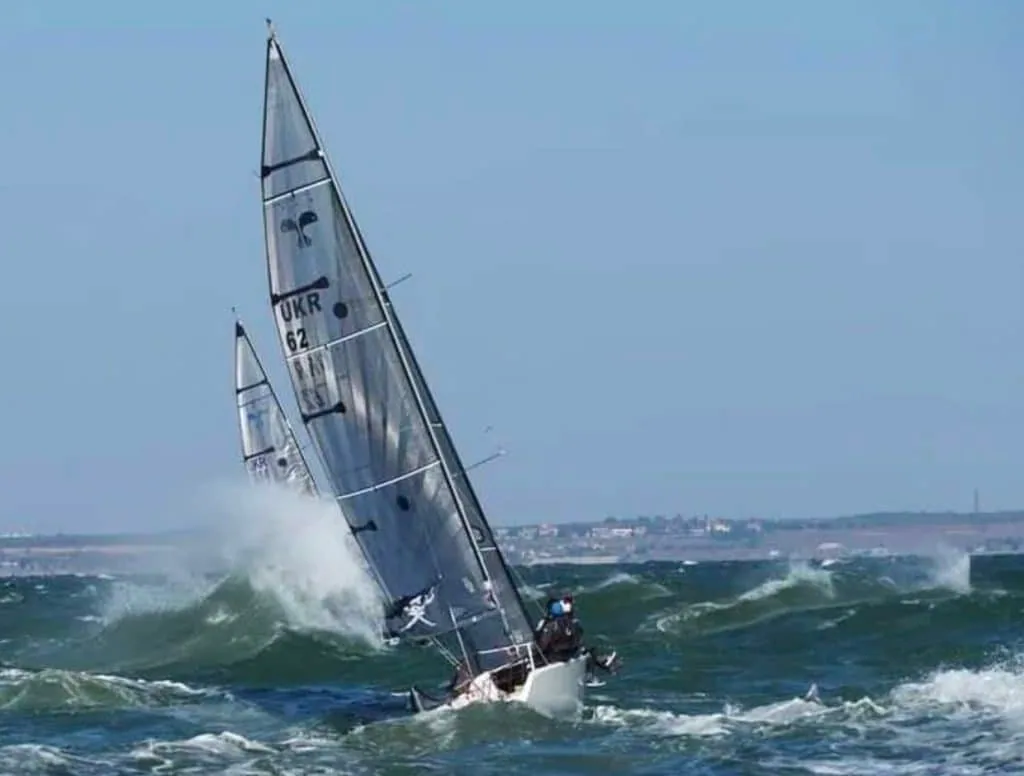 Platu 25 sail number UKR 62 heeled hard, crashing through a wave in a fresh breeze