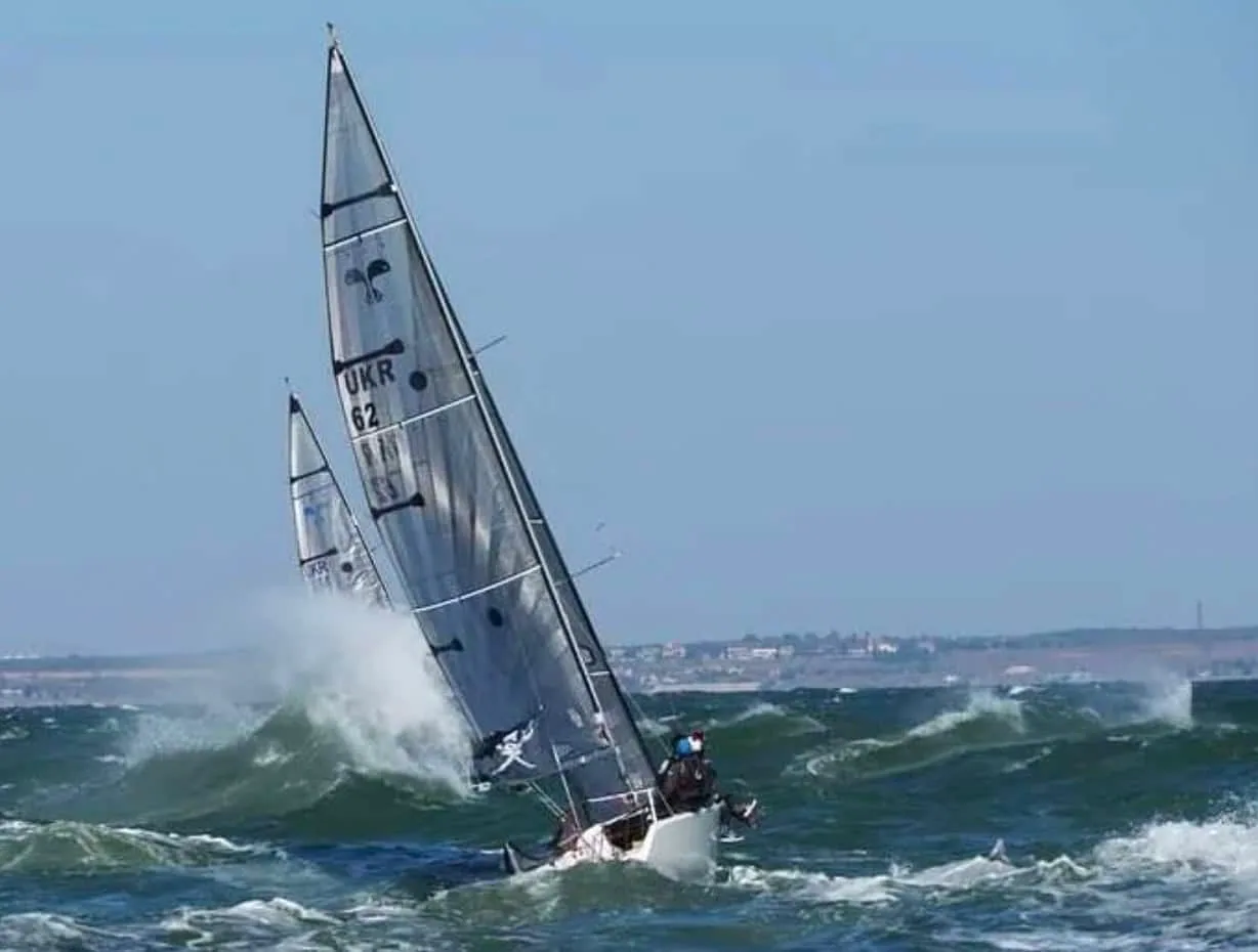 Platu 25 sail number UKR 62 heeled hard, crashing through a wave in a fresh breeze