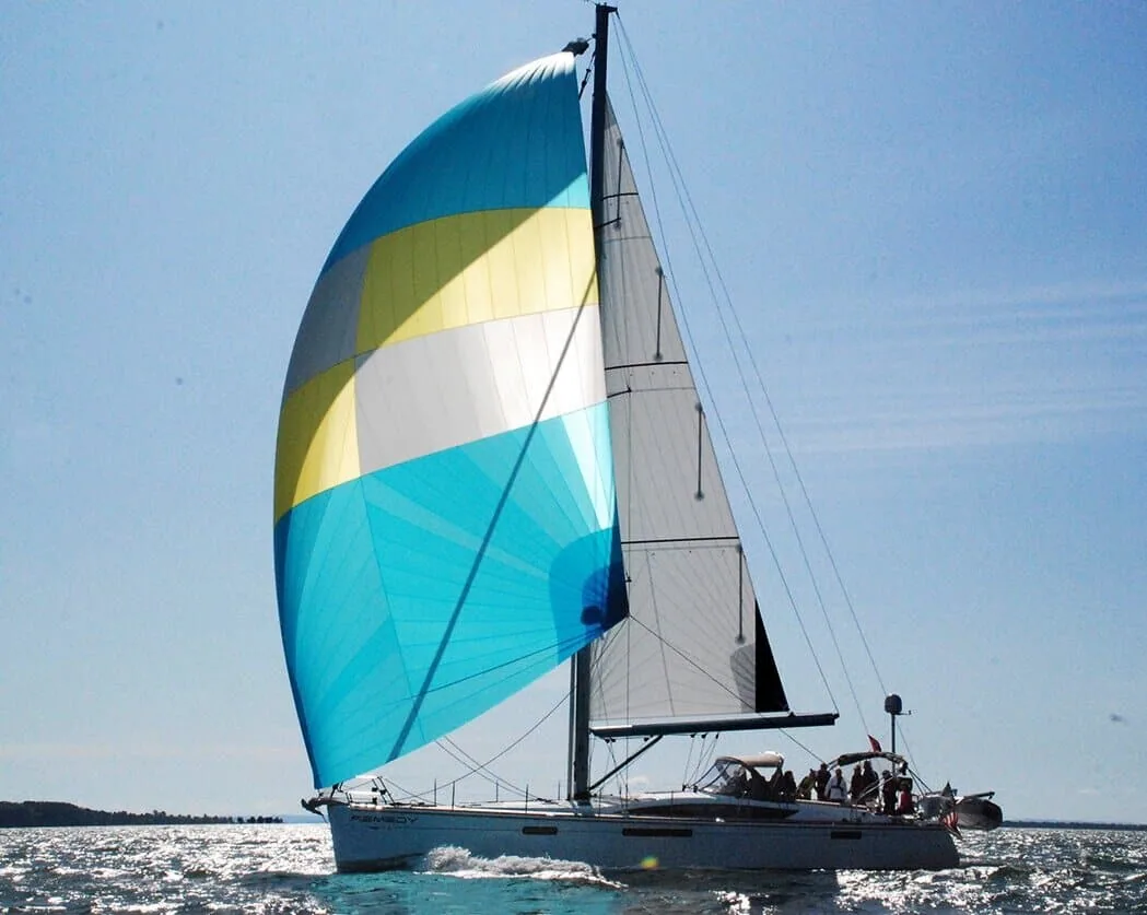 Jeanneau 57 reaching under a blue, yellow and white cruising gennaker