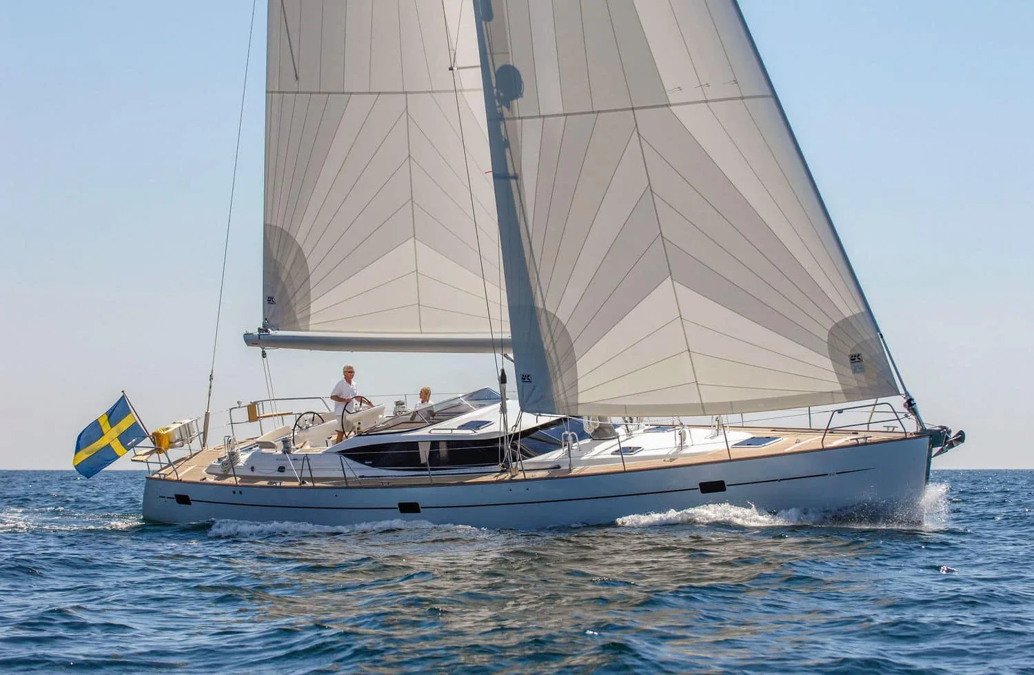 Cruising sloop with a Swedish flag sailing under a Spectra radial main and genoa