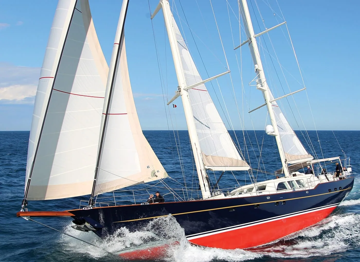 Kestrel, a dark-blue classic yacht, sailing under her Dacron cruising genoa and other sails