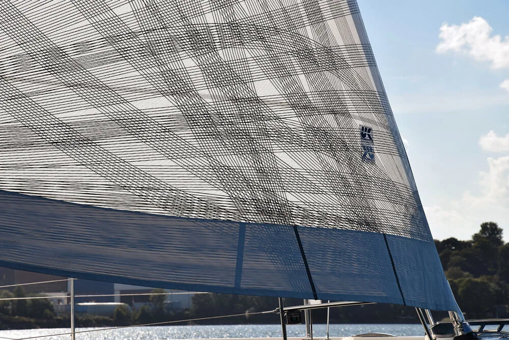 Close-up of a grey plaid X-Drive® genoa with land visible in the distance