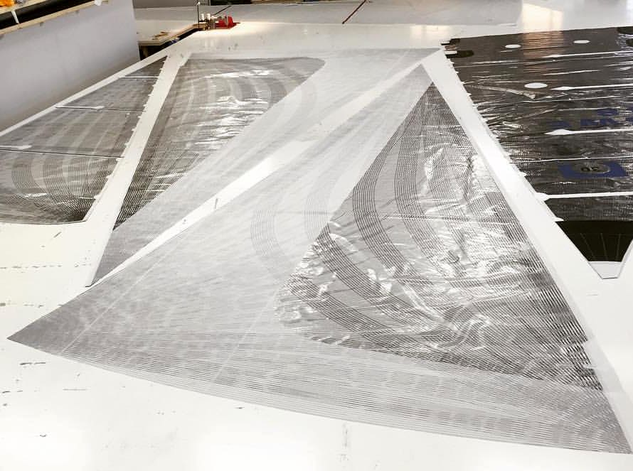 Triangular taffeta panels laid out on a sail loft floor for a genoa