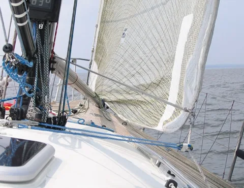 Close-up of a jib's mesh telltale window and a blue inhauler line rigged on deck