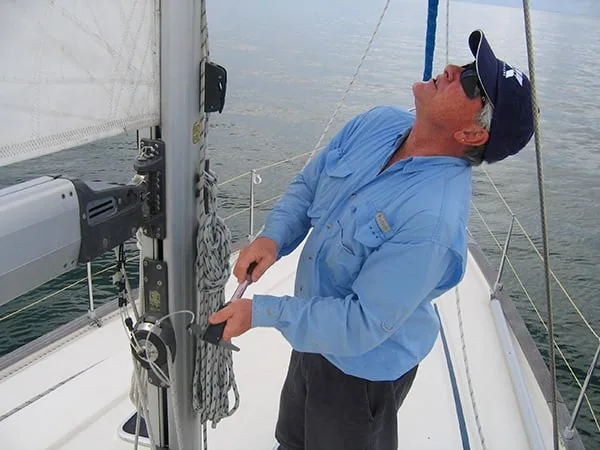 UK Sailmakers representative in a company shirt looking up the mast on a sailboat