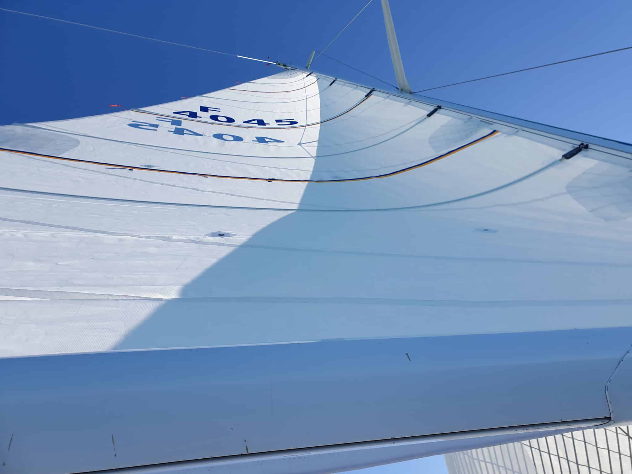 View up a white Dacron Voyager cruising mainsail numbered 4045, seen from the boom