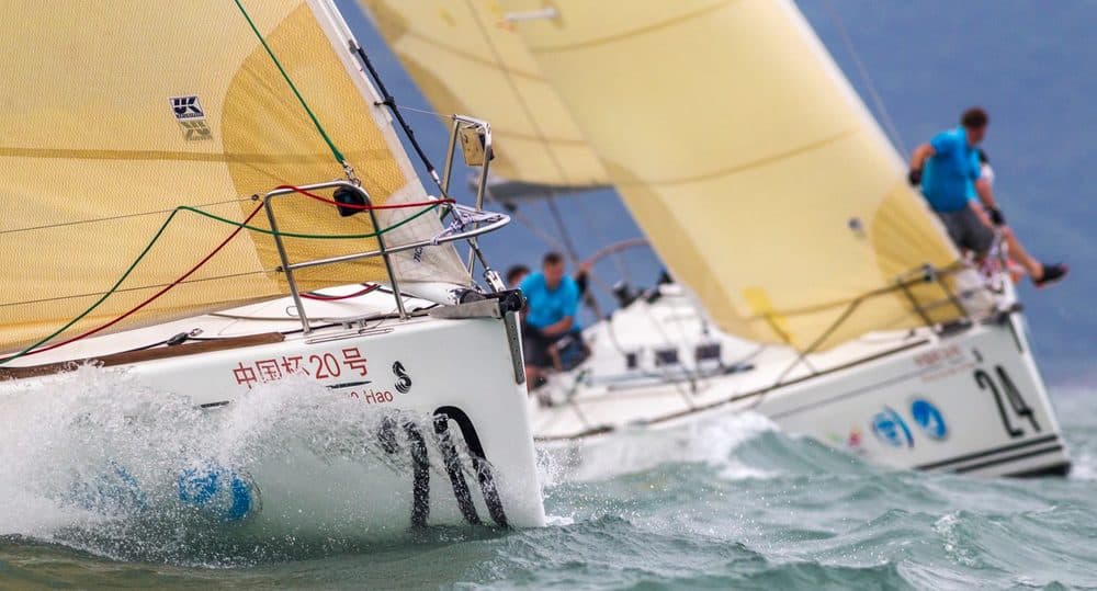 Racing yachts close together under yellow spinnakers at the China Cup regatta