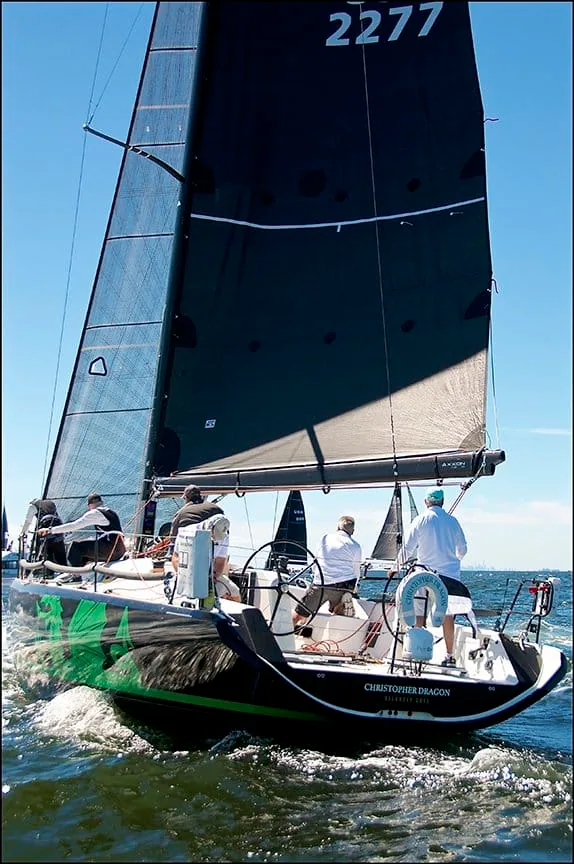 Christopher Dragon reaching under mainsail and spinnaker, crew in red on the rail