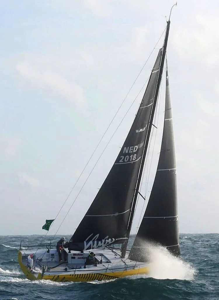 Offshore racer NED 2018 reefed under twin dark headsails, crew hiking hard, spray flying