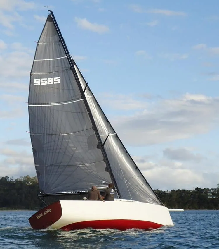Yacht Intrigue racing under spinnaker and mainsail, sail number 9585