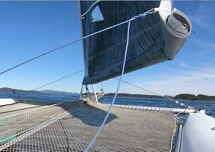 Small hanked-on jib reefed for heavy air, crew of four hiking on a sportboat's rail
