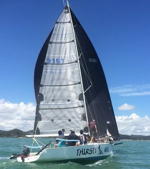 Thirsty Work, sail number 9181, sailing hard under black sails