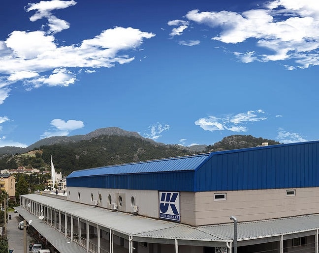 Exterior of the UK Sailmakers loft building with mountains in the background, Türkiye