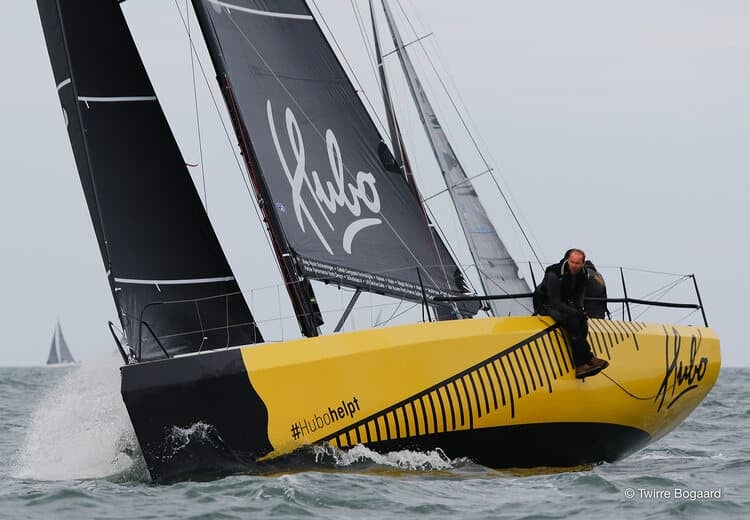 Yellow and black yacht HUBO sailing upwind with matching black sails