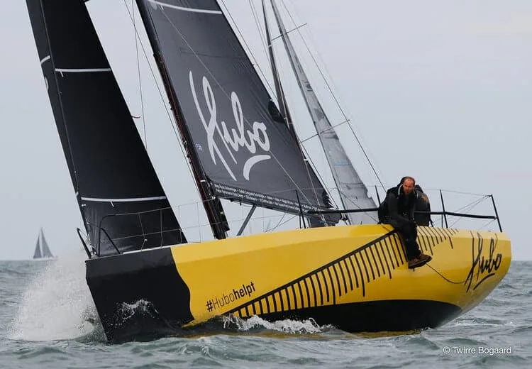 Yellow and black yacht HUBO sailing upwind with matching black sails