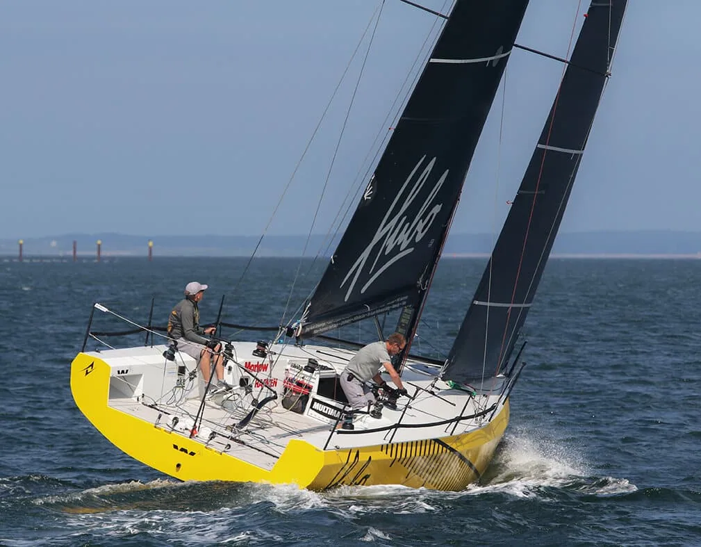 Erik van Vuuren's yellow-hulled Waarschip 36 HUBO reaching under dark sails, two crew aboard