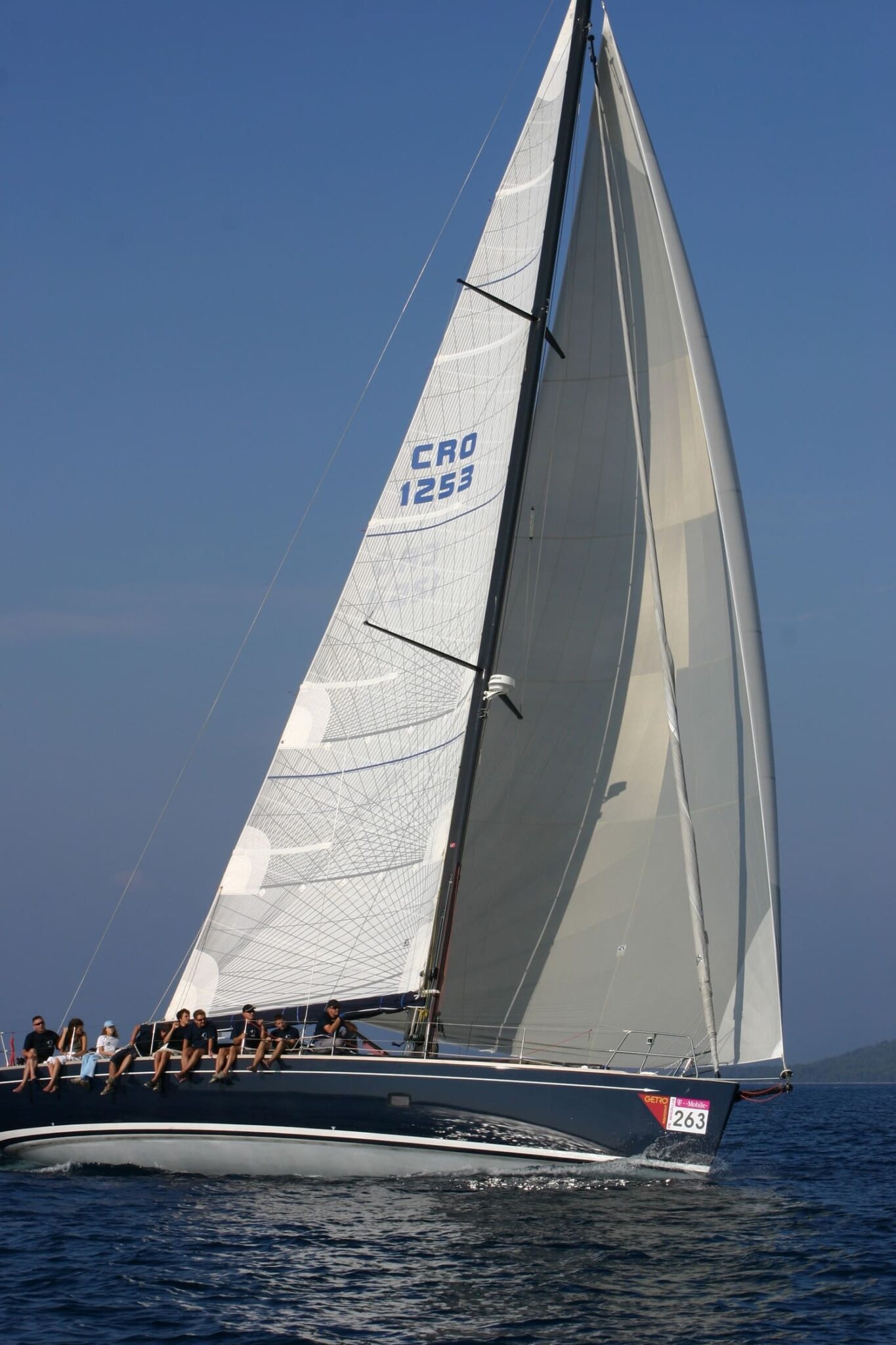 Croatian-flagged yacht CRO 1253 sailing close-hauled with crew hiking on the rail