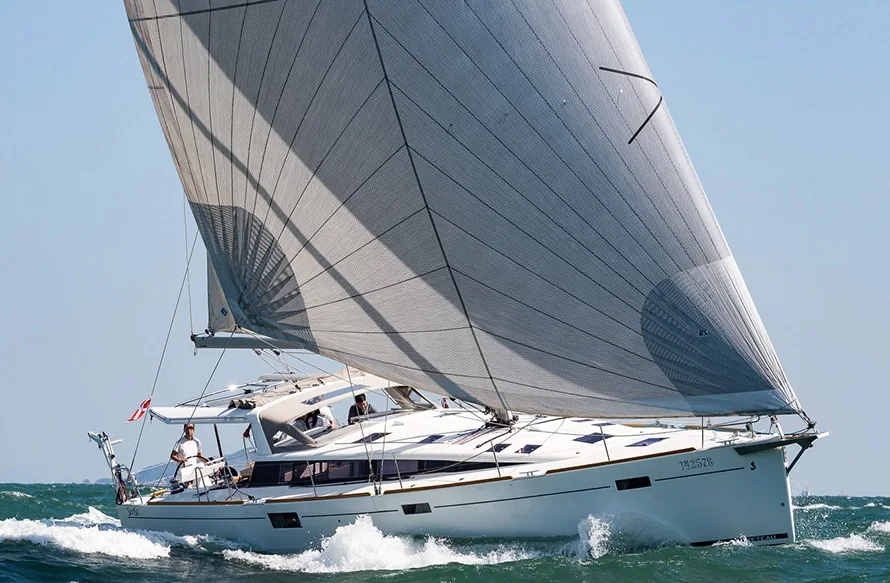 Cruising sailboat reaching under a grey asymmetric Code Zero spinnaker