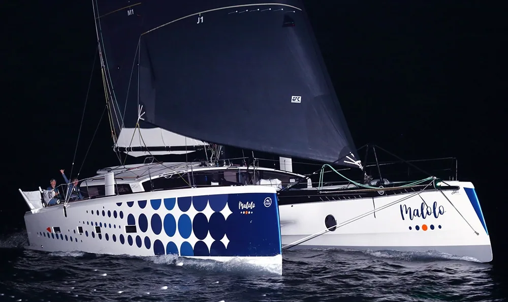 Catamaran Malolo finishing the ARC 2022 at night under spinnaker