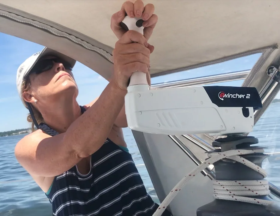 Sailor using an Ewincher 2 to grind a winch aboard a cruising boat