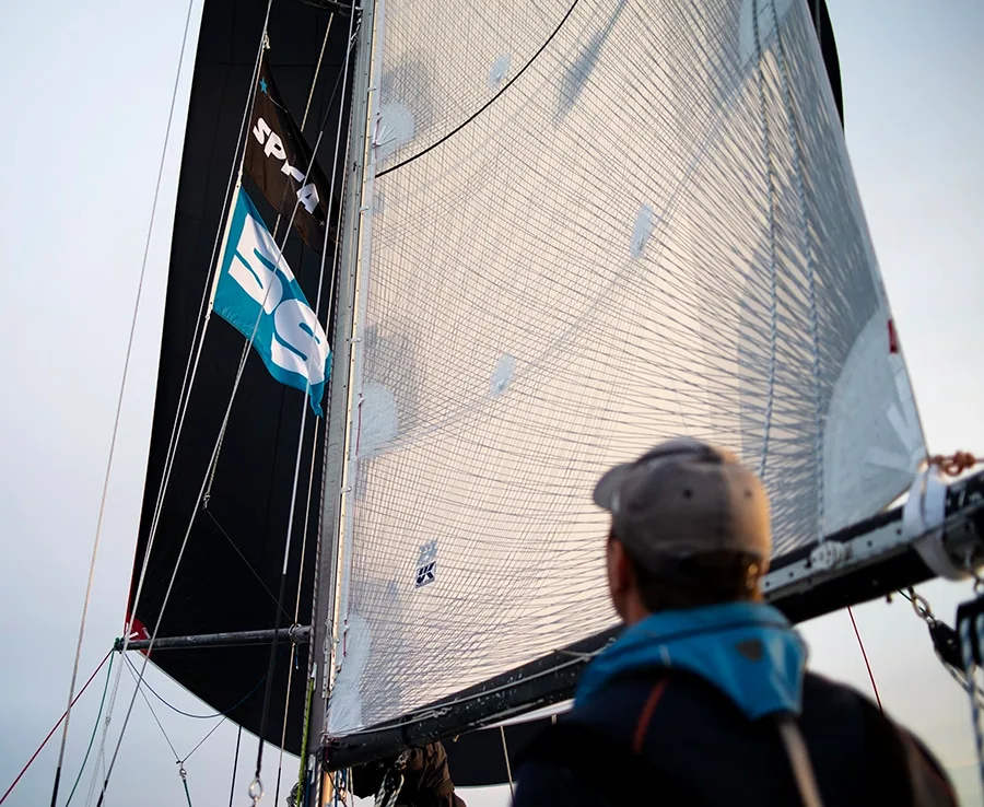 Crew member looking up at a full genoa on the Sailing Academy's Farr 65