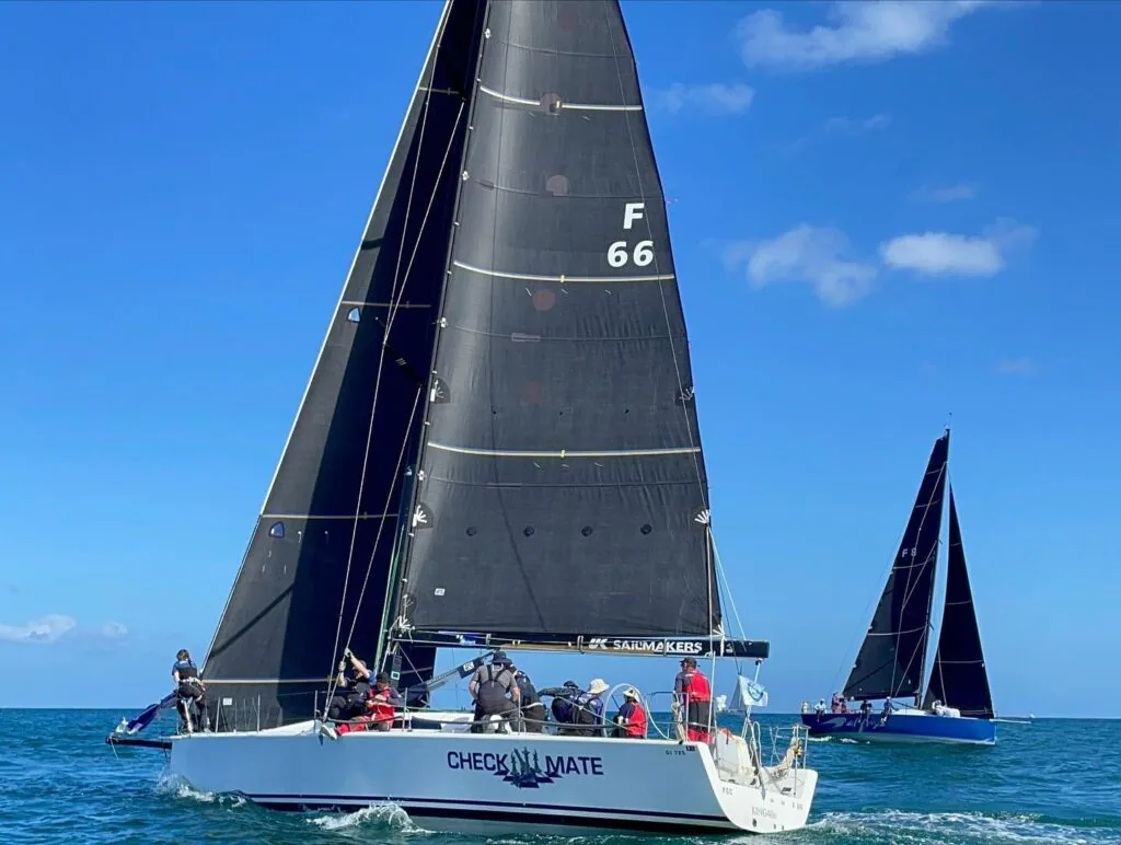 Check Mate, sail F66, racing under a dark UK Sailmakers mainsail with rival astern