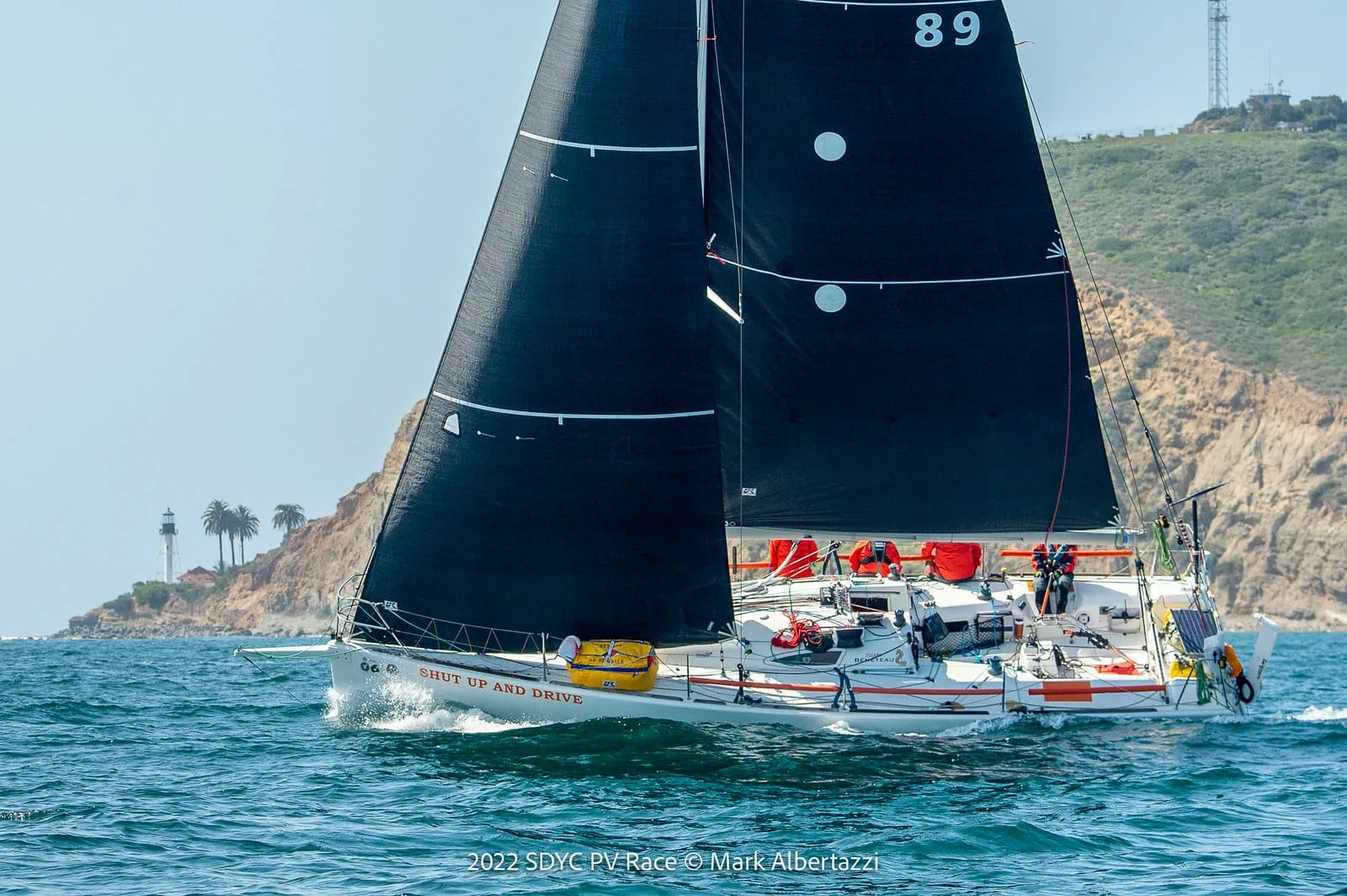 Nathalie Criou at the helm during an offshore race, crew working the rail behind her