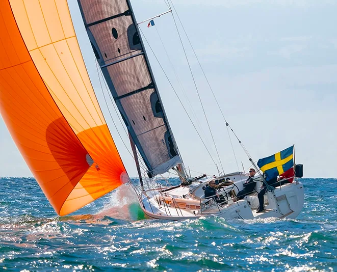 Linjett 39 flying an orange cruising chute alongside its X-Drive® mainsail