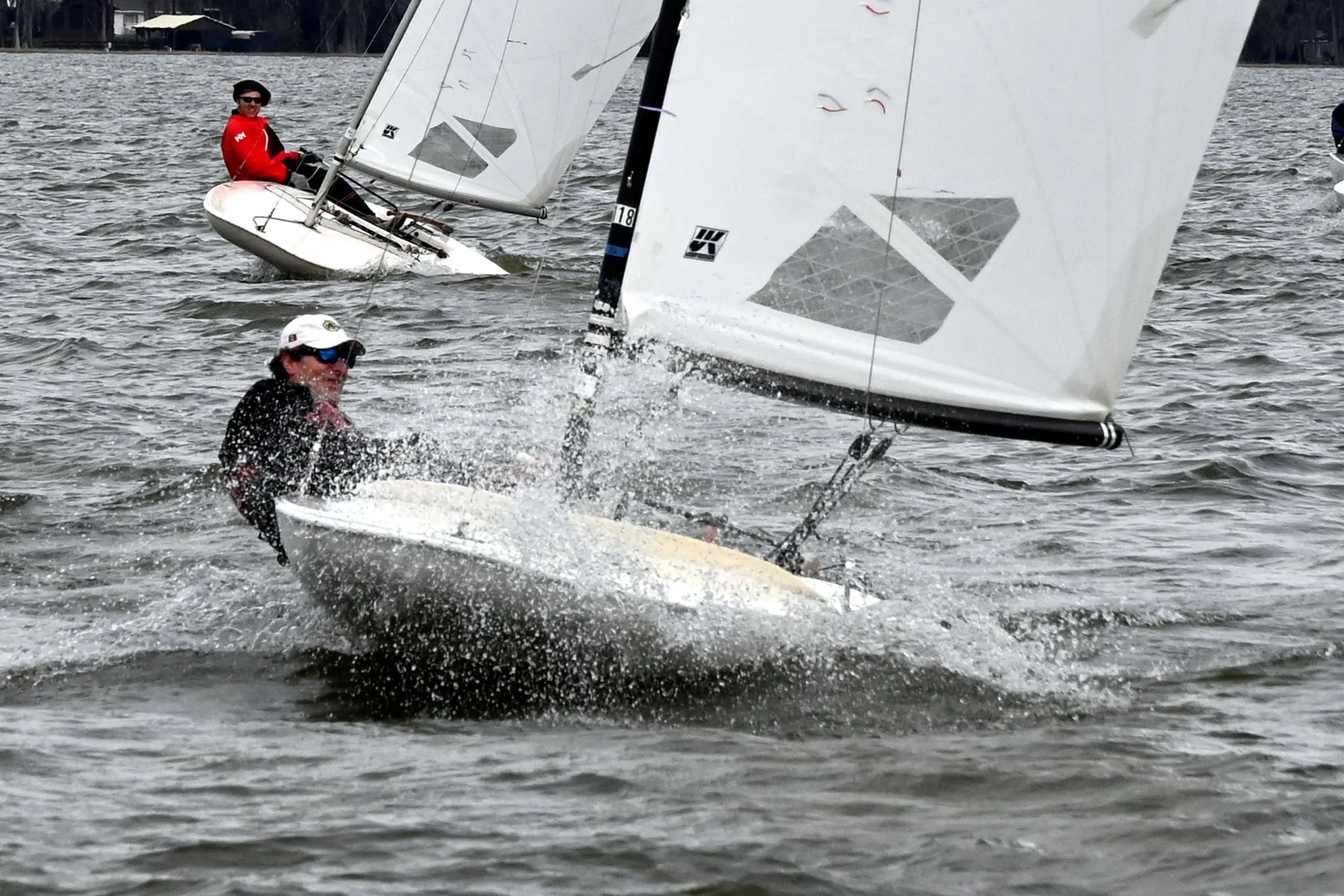 MC Scow sailor hiking hard to keep the boat flat in a gust