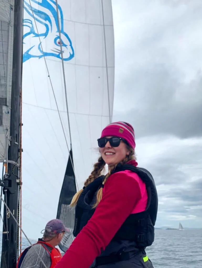 Heather Mahady on the foredeck, spinnaker with a rabbit logo overhead