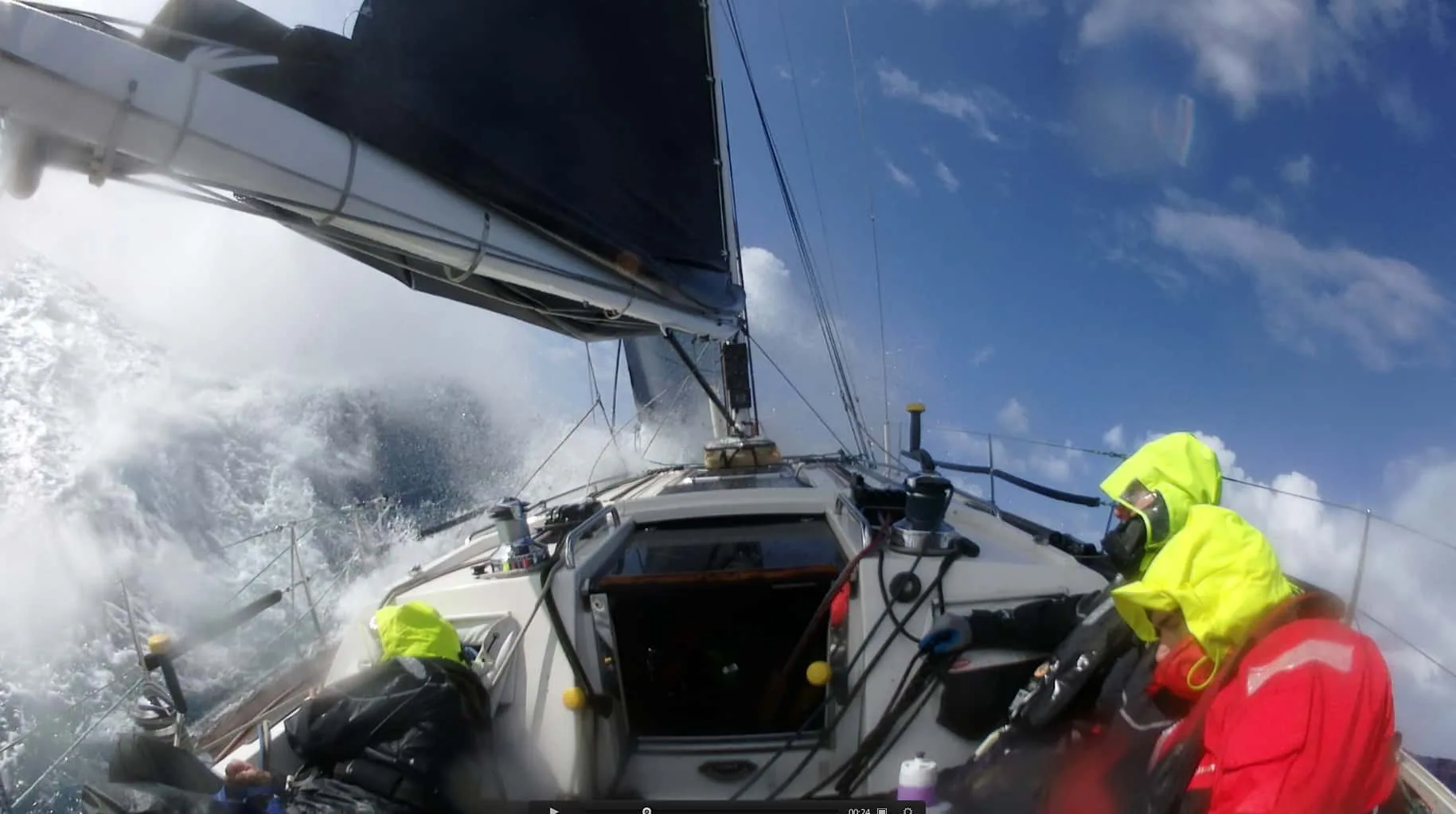 Triple Lindy's bow buries into a wave as crew in foul-weather gear hold on offshore