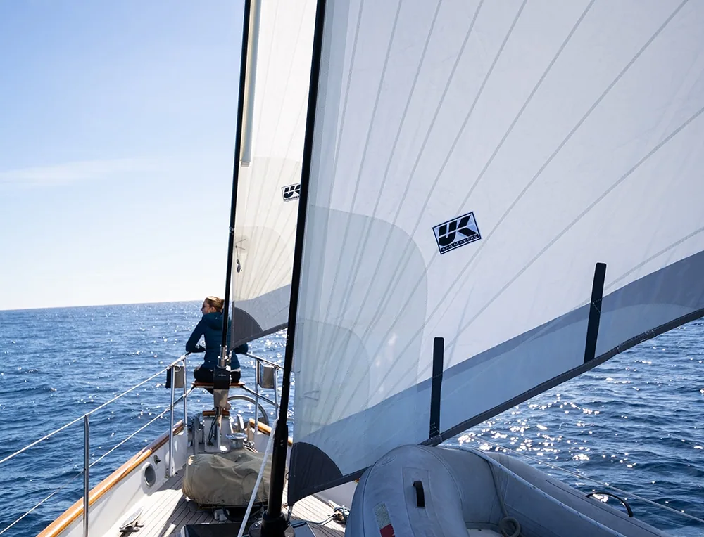 Crew member checks the mainsail aboard a cruising yacht in Mexico's Sea of Cortez