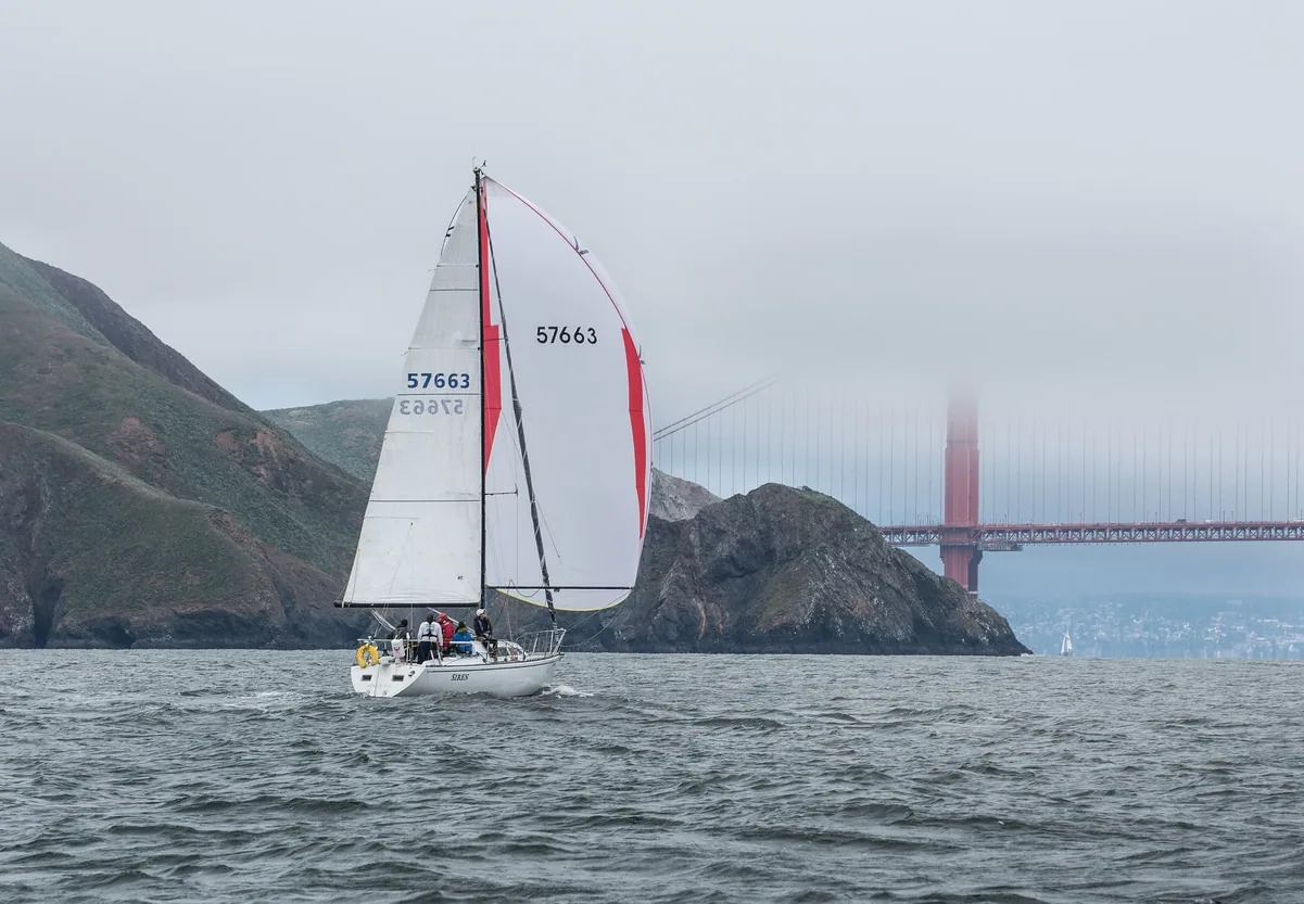 Siren sails toward a fog-shrouded Golden Gate Bridge under spinnaker