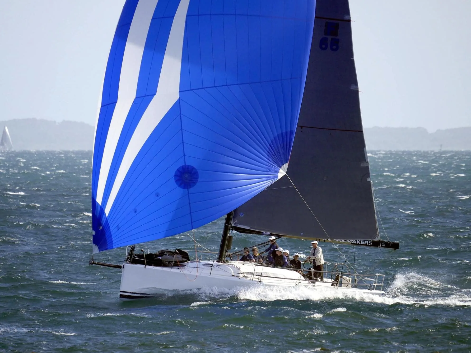 King 40 Checkmate runs downwind under a blue asymmetric spinnaker