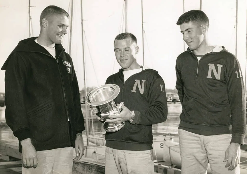 Butch Ulmer and Naval Academy teammates hold a silver trophy cup, 1960s photo