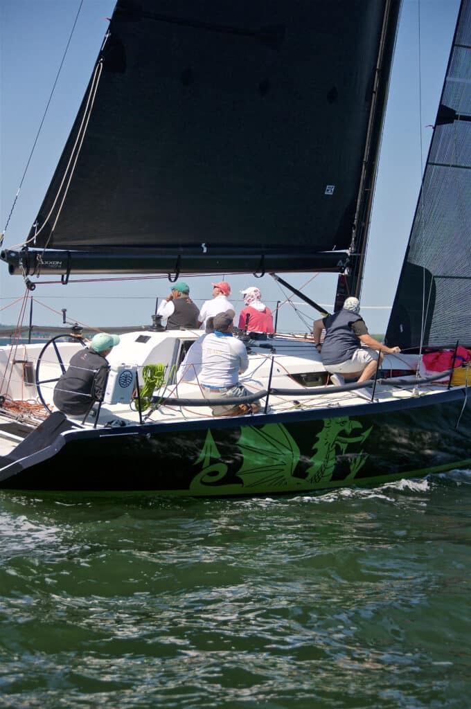 Crew hikes hard on Christopher Dragon's rail, dragon graphic on the hull