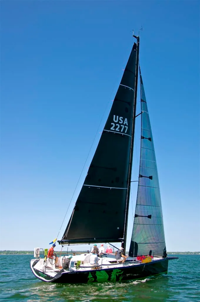 Christopher Dragon sails upwind under black sails, USA 2277 on the main