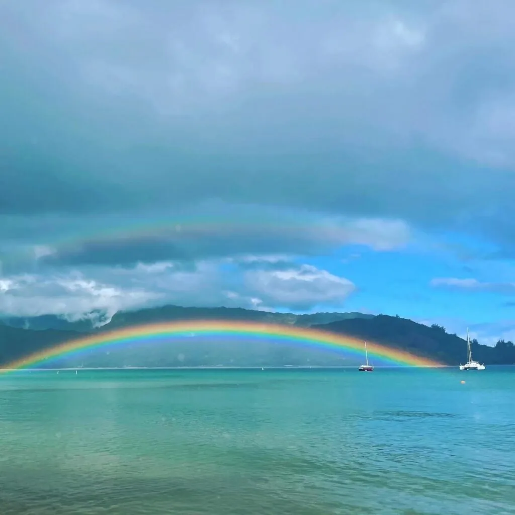 Double rainbow over Hanalei Bay, Kauai, with two sailboats at anchor