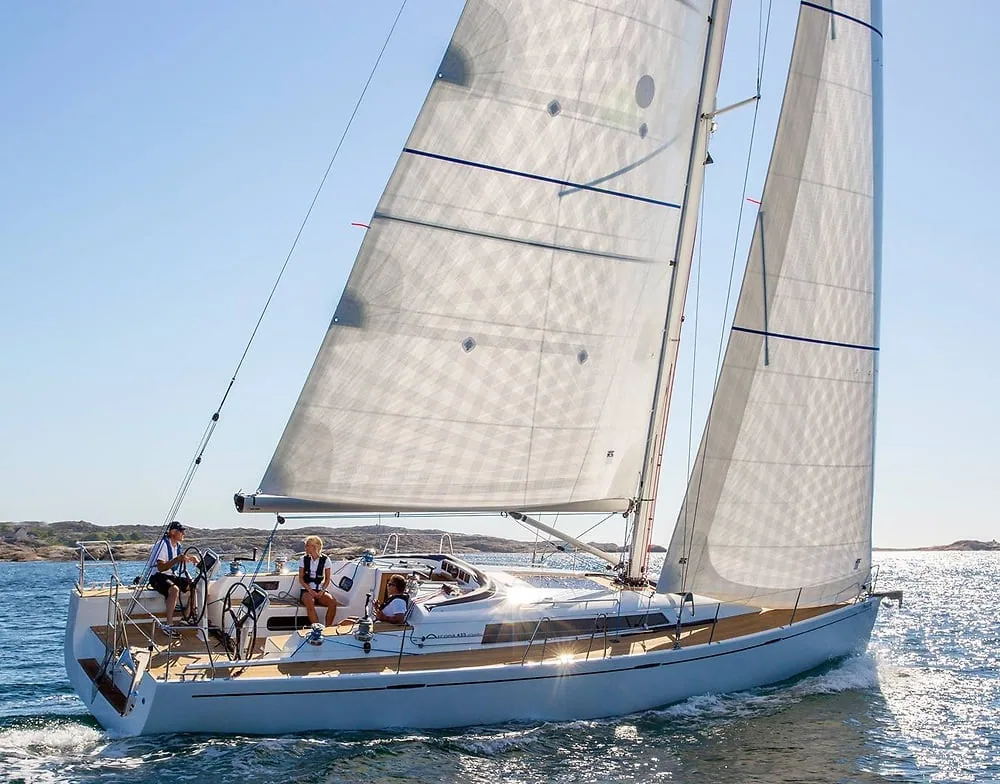 Arcona sailboat sailing upwind with three crew, full main and jib set
