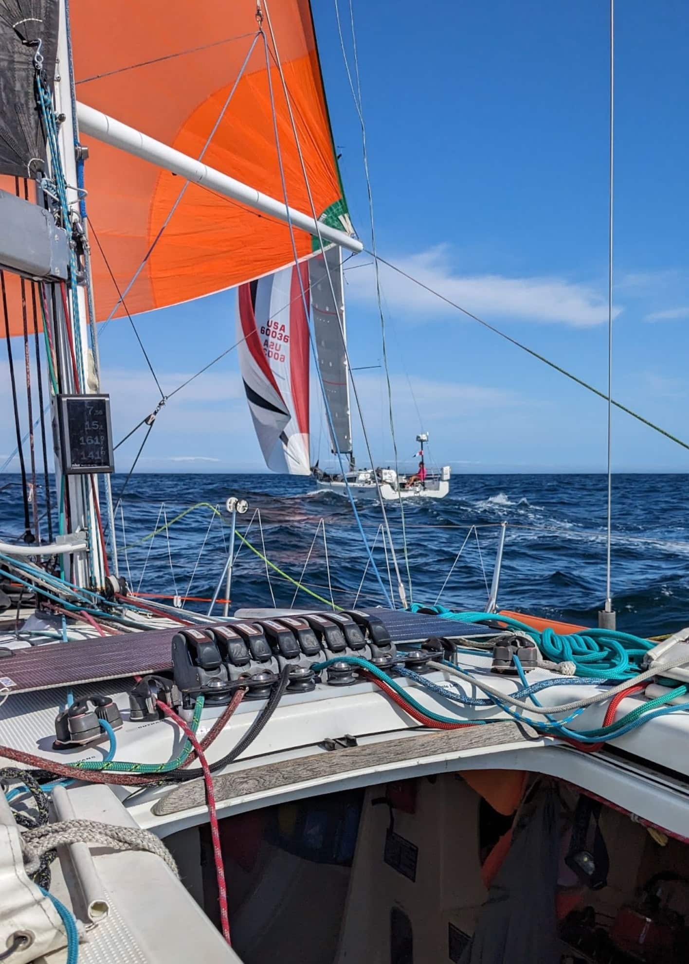 View forward from ENVOLEÉ's cockpit with orange and red spinnakers set, another yacht ahead