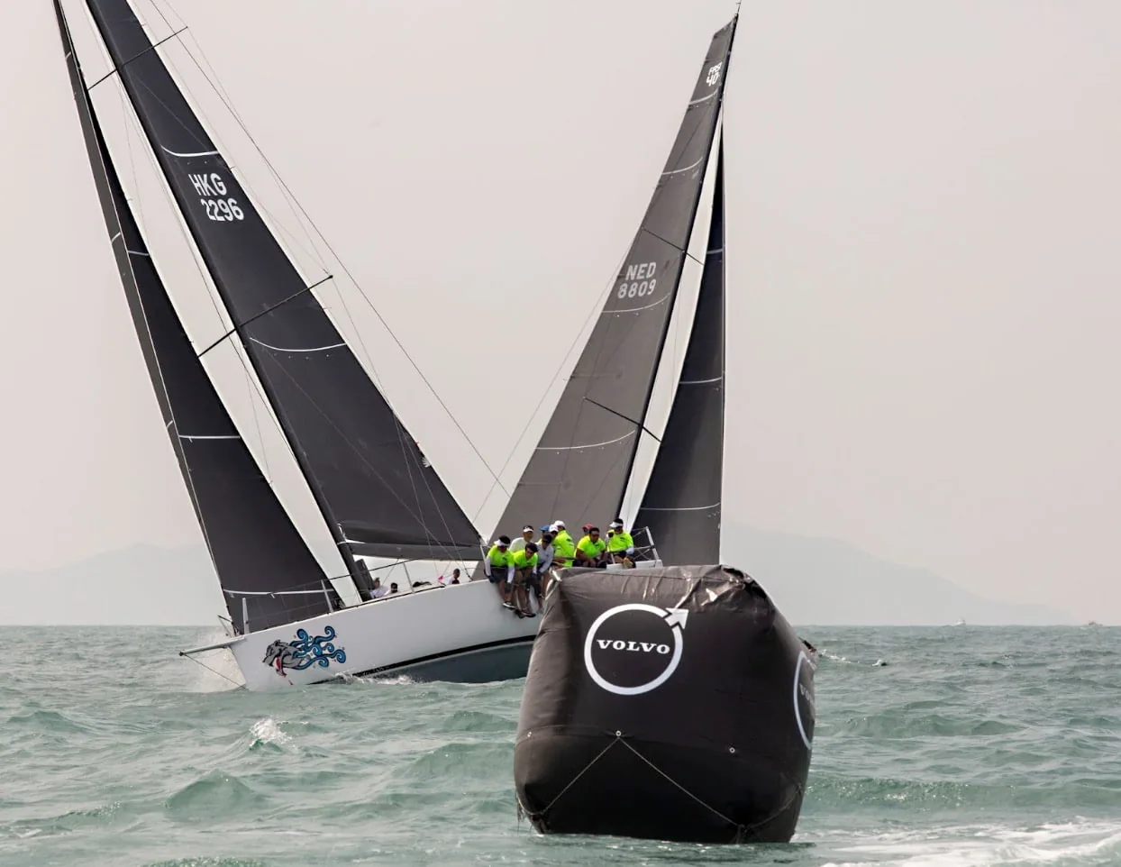 Two boats cross tacks near a Volvo course mark during the Volvo China Coast Regatta