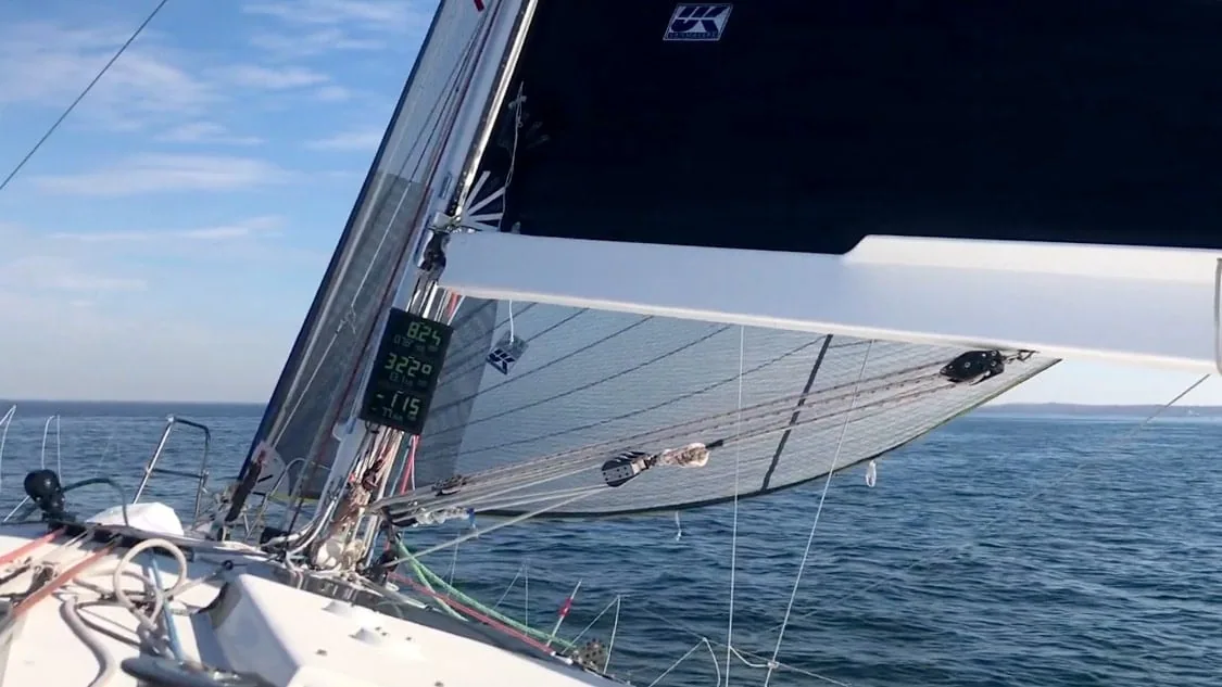 Furling reacher sail sheeted in with the boat's instrument display visible in the cockpit