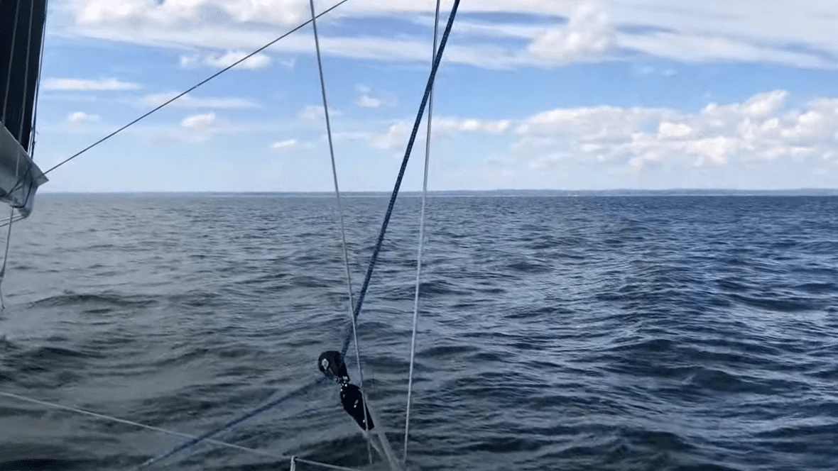 View forward over the bow and a staysail sheet block toward open water