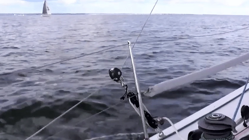 Tweaker block and line rigged at the rail, another sailboat visible in the distance