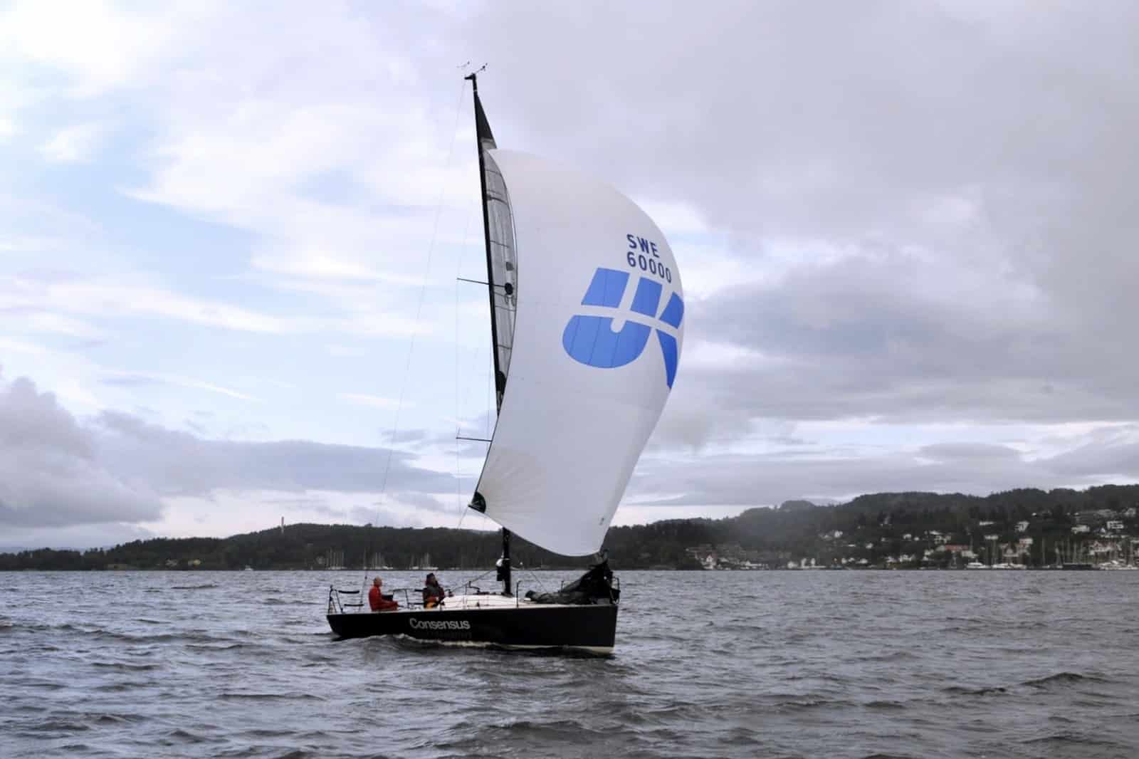 Farr 30 CONSENSUS reaching under a blue-and-white UK Sailmakers spinnaker