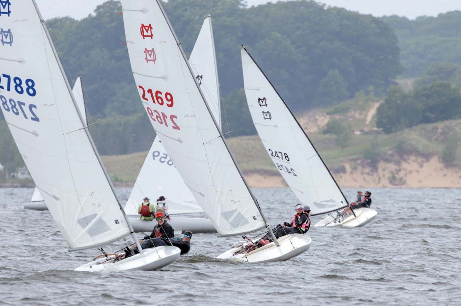 MC Scow fleet racing upwind with UK sails leading, numbers 2788 and 2169 visible
