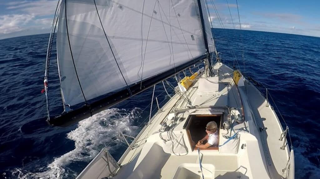 Christian Williams at the companionway of his sailboat, reaching offshore