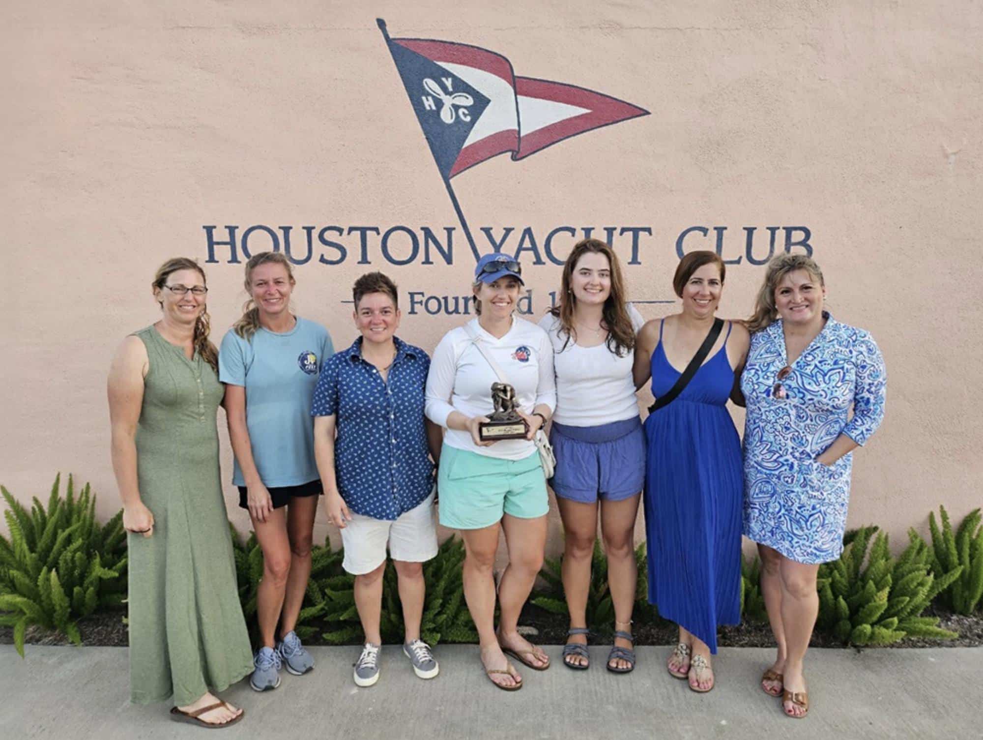 Meghan Pesch Mutlu and the BON BON crew pose by the Houston Yacht Club sign after their win.