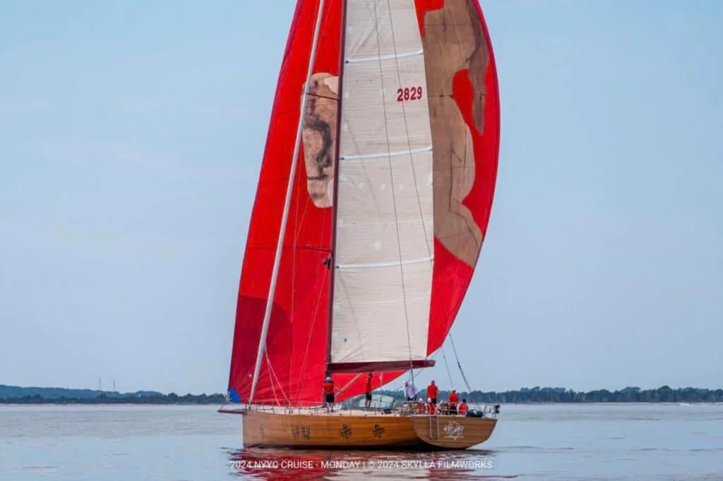 Classic yacht 2829 sails under a red-and-white spinnaker at the 2024 NYYC Annual Cruise.