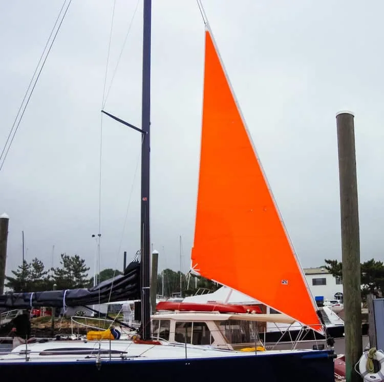 A bright orange storm jib set on the forestay in heavy weather